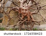 Sun with face made of tree root. Wooden decoration. Dried fibrou
