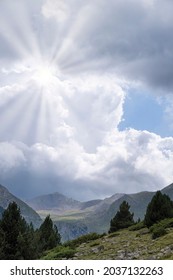 the sun filtering through the clouds on a cloudy day in a mountain landscape, copy space, vertical