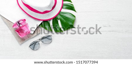 Sun glasses and hat on white wooden background. Top view. Free copy space.