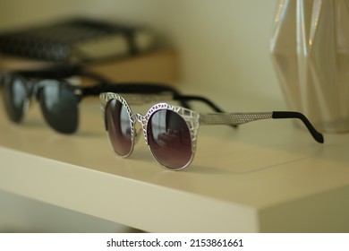 Sun glasses' s women on white shelf in store. Close up eyeglasses beach with aluminum frame for sun protection. Woman accessories for fashion and beauty. Luxury blinkers
