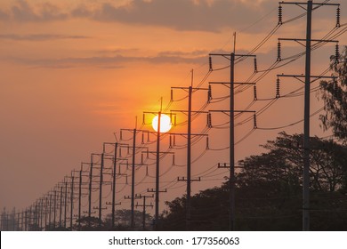 Sun goes down and there is a long line of electricity post in front.