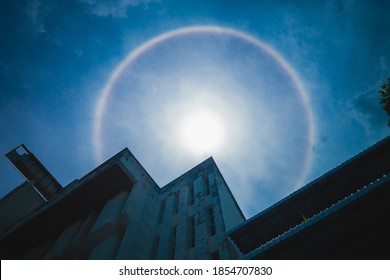 Sun halo or Circumscribed halo, sun corona rainbow clouds and blue sky with building background, Natural phenomenon.
The silhouette of sun halo at noon with circular rainbow.