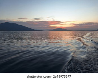 The sun has just risen, illuminating the horizon on the southern coast of Flores Island, East Nusa Tenggara, Indonesia, bathing the blue sea and sky with a tinge of yellow light.