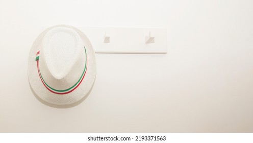 Sun Hat On White Coat Rack In The Hallway