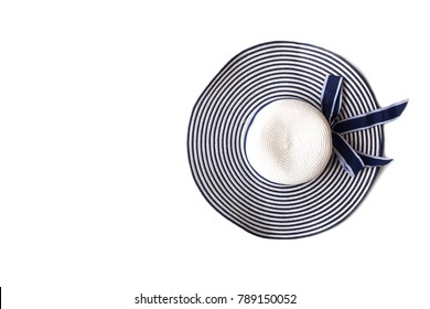 Sun Hat On White Isolate Background. Top View With Copy Space. White And Navy Blue Color Striped And Bow. Favorite Accessories For Vacation, Summer Or Beach Event.