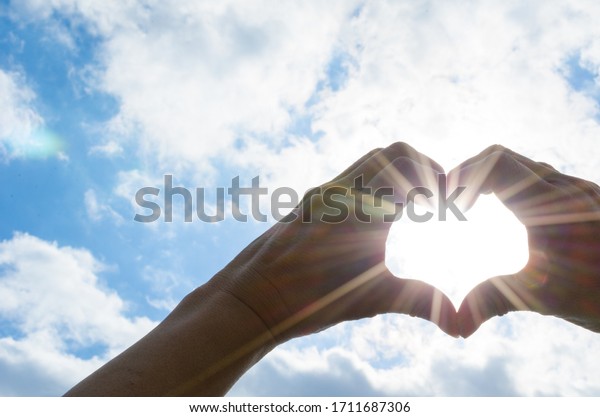 The sun in heart shaped\
hands