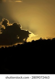 Sun hiding behind the clouds and the clouds of the sun in a dark cloud 