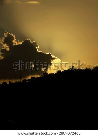 Sun hiding behind the clouds and the clouds of the sun in a dark cloud 