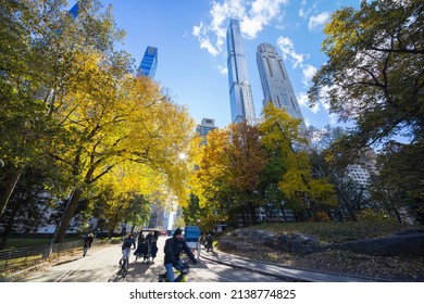 The sun illuminates autumnal leaf color trees in Central Park from among the Ultra-luxury high-rise residential skyscraper in Billionaires’s Row on November 16,  2021 at New York City NY USA.