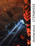Sun light rays shining into cave in Halong Bay, Vietnam. Natural and colorful cave light ray