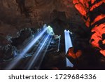 Sun light rays shining into cave in Halong Bay, Vietnam. Natural and colorful cave light ray