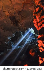 Sun light rays shining into cave in Halong Bay, Vietnam. Natural and colorful cave light ray
