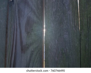 Sun Light Shining Through Crack In Wood Fence