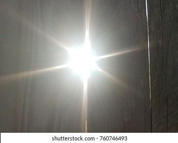 Sun Light Shining Through Crack In Wood Fence