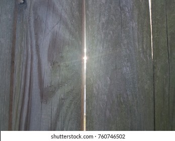 Sun Light Shining Through Crack In Wood Fence