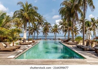 Sun loungers and umbrellas near the swimming pool. Destination holiday. Indonesia. - Shutterstock ID 2164398477