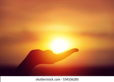 Sun on female hand. Silhouette of hand holding sun
