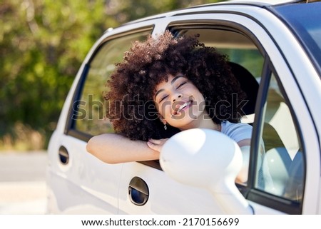 Sun on my face, joy in my heart. Shot of a beautiful young woman enjoying an adventurous ride in a car.