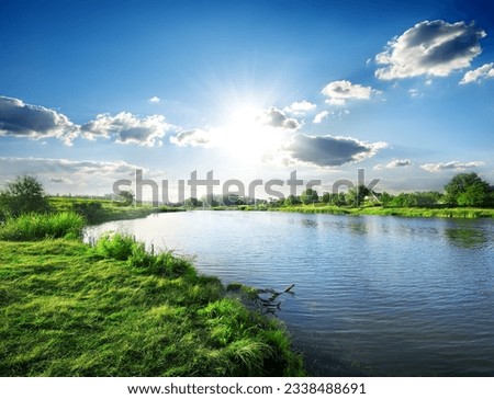 Sun over calm river in the spring morning