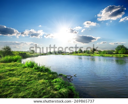 Sun over calm river in the spring morning