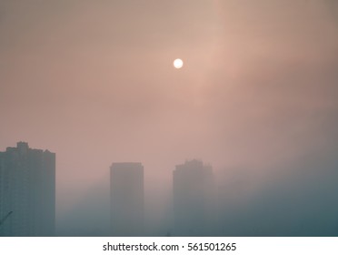 Sun Over Foggy City.  Dense Fog Envelops The Residential Area. Buildings Sticking Out Of The Fog.