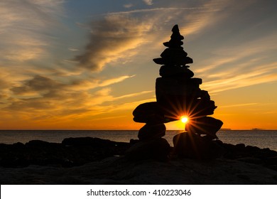 The Sun Peaks Through A Cairn Of Rocks Along The Coast Of New England.  