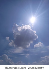 The sun peeking through the clouds, creating a beautiful and radiant scene in the sky.