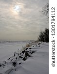 The sun peeks out from behind the clouds on a frigid cold morning in Wisconsin along the Great Lake Michigan. 
