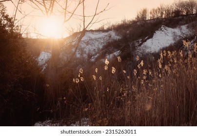 The sun peeks over a snow-covered winter landscape at the Scarborough Bluffs on a cold winter evening in Toronto, Ontario, Canada. - Shutterstock ID 2315263011