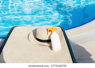 Sun protection essentials on poolside lounger with straw hat beside blue water, summer vacation safety concept for skincare, tourism wellness, UV prevention, leisure lifestyle, seasonal travel promotion