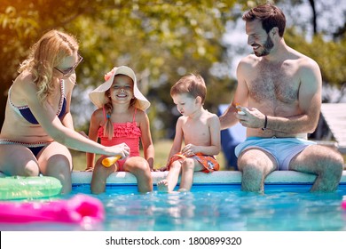 
Sun Protection - Family Put Suncream On Little Smiling Children Before Swimming.