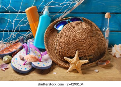 Sun Protection Still Life With Straw Hat,sunglasses,flip-flops And Suntan Lotion Bottles On The Beach 