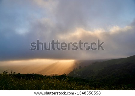 Sun ray coming from the clouds over Santa Cruz mountain range, California.