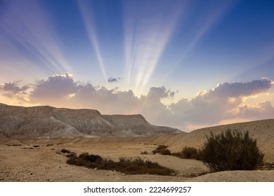 Sun rays from behind the clouds during a beautiful sunset in the desert