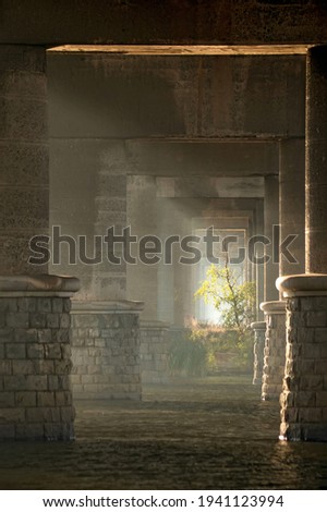 Sun rays between the bridge pillars in the morning. Paton bridge over Dnipro river, Kyiv, Ukraine