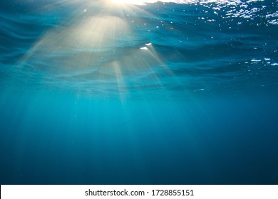 Sun rays braking the water surface. Underwater image taken scuba diving in Indonesia