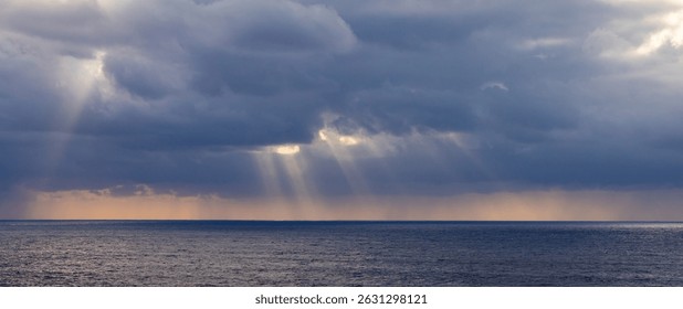 Sun rays break through dramatic clouds over the Pacific Ocean during twilight hours. - Powered by Shutterstock - Get 15% off with code: PIKWIZARD15