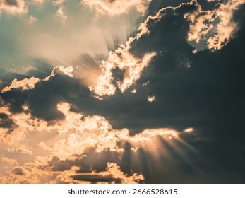 Sun rays breaking through a cloud in a clear blue Sky