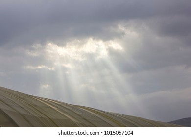 sun rays breaking through the clouds over a mountain landscape