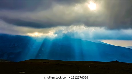 Sun rays breaking through the clouds, mountain view