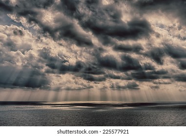 Sun rays breaking through the clouds over a ocean landscape. Real HDR photo
