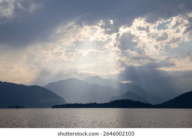Sun Rays Breaking Through Clouds Above Peaceful Mountain Landscape
