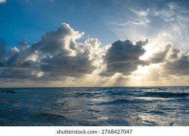 Sun rays breaking through clouds over Atlantic Ocean in Miami. Crepuscular sun rays shining through heavy clouds over sea waves at Miami Beach, Florida, USA.