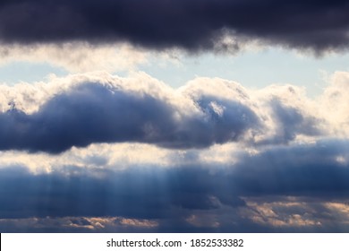 Sun rays breaking through cumulus clouds. The concept of divine light, a glimmer of hope or overcoming difficulties. Spiritual religious abstract background.