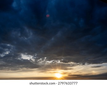 Sun rays breaking through dramatic storm clouds at sunset