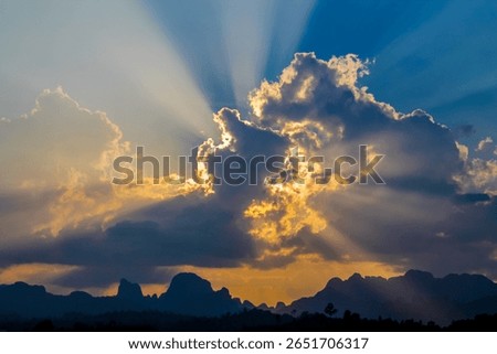 Sun rays breaking through dramatic clouds, atmospheric sky, natural light beams, scenic weather, celestial sunlight, nature background, ethereal landscape, peaceful, sky view, sunburst, outdoors.