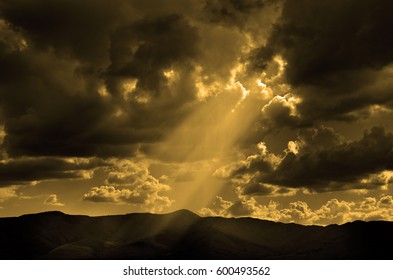 Sun rays in clouds with mountains