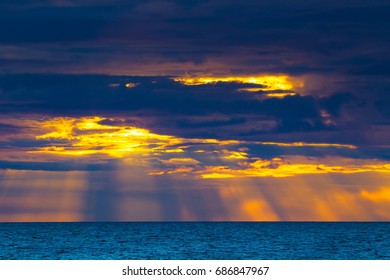 Sun rays. Clouds with sunlight. Beautiful sunset over the sea.