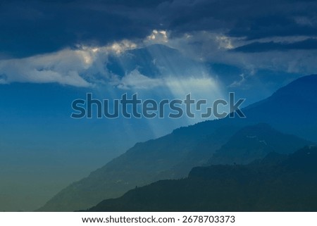 Sun rays coming out of cloud burst - at Rabangla, Sikkim, India. Himalayan mountains in background. Brilliant scenic image of Great Himalayas of Sikkim.