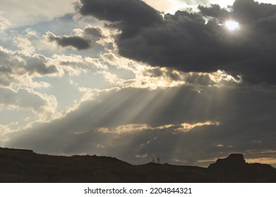 Sun rays flitering through sunset clouds shown in the Mojave Desert, California, United States.
